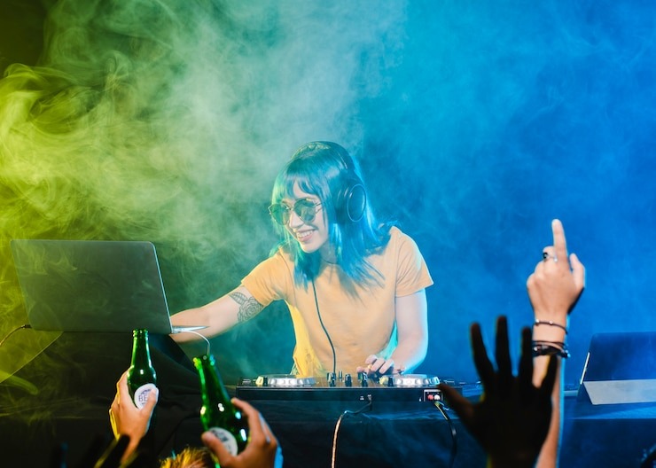 a dj at the party smiling while playing music